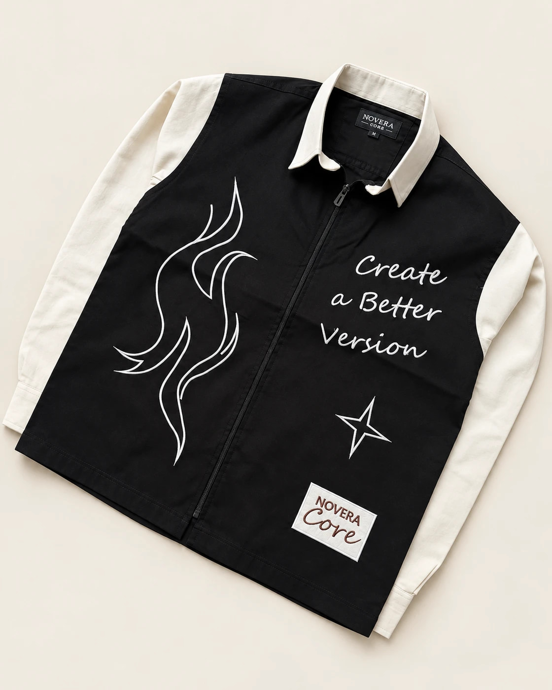 Black zip-front shirt with ivory collar and sleeves, white abstract embroidery and Create a Better Version lettering