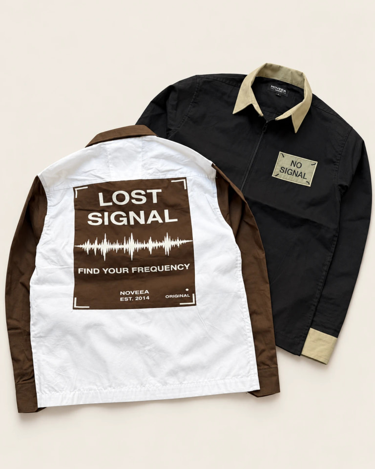 Two samples: a black and khaki zip shirt with a No Signal patch and an ivory and brown shirt showing a Lost Signal back print